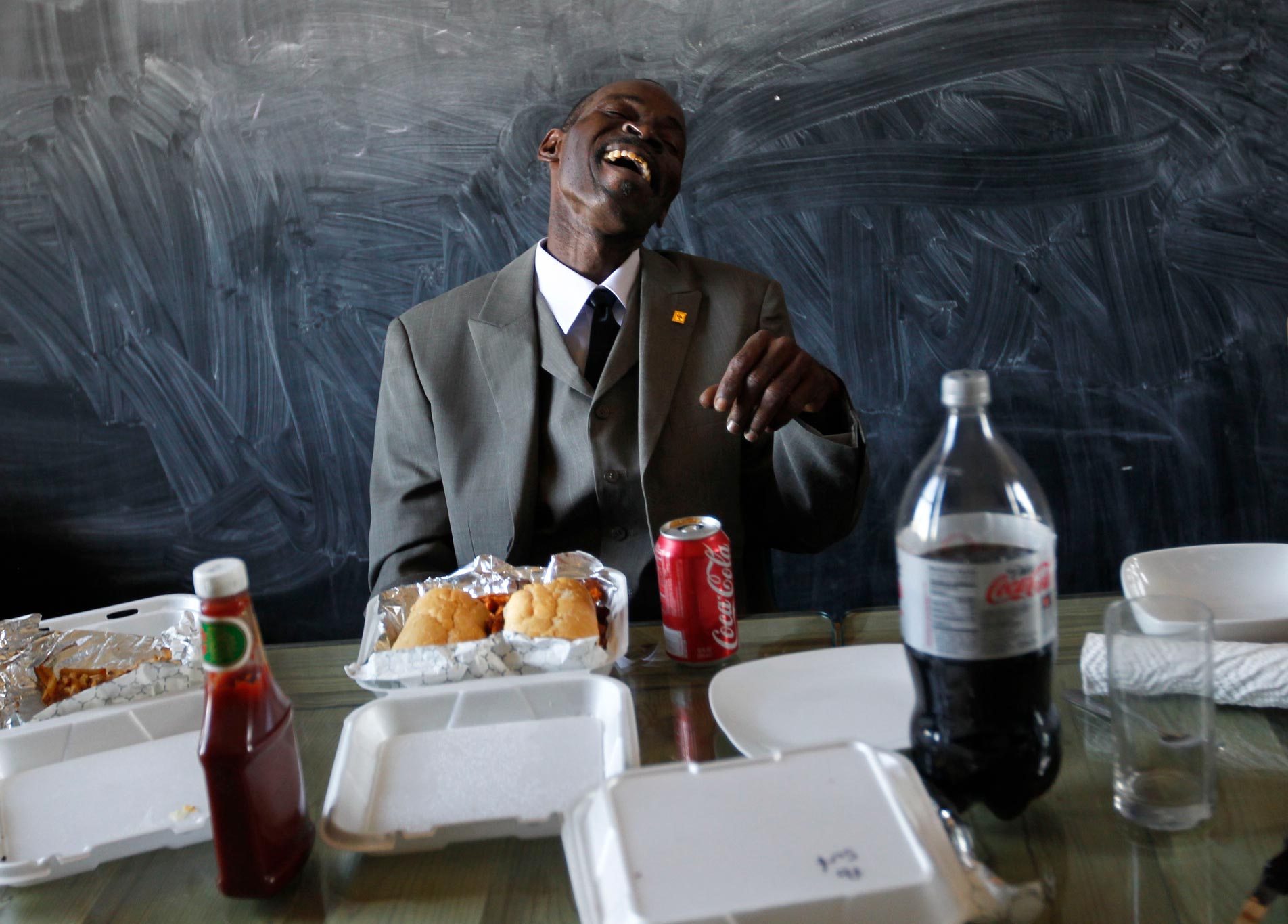 Henry James, who was exonerated from a rape conviction for which he served 30 years in prison, laughs as he eats his first meal, a shrimp po-boy and sweet potato fries, after being released from the Louisiana State Penitentiary in Angola, inside the offices of the Innocence Project New Orleans on Oct. 21, 2011. (Image: AP Photo/Gerald Herbert)