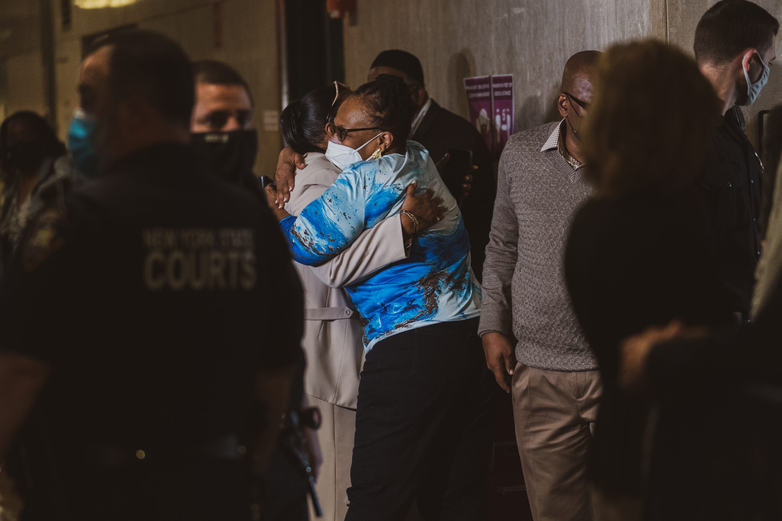 Muhamad Aziz's family members hug at the court before his exoneration hearing.(Image: Jeenah Moon for the Innocence Project)