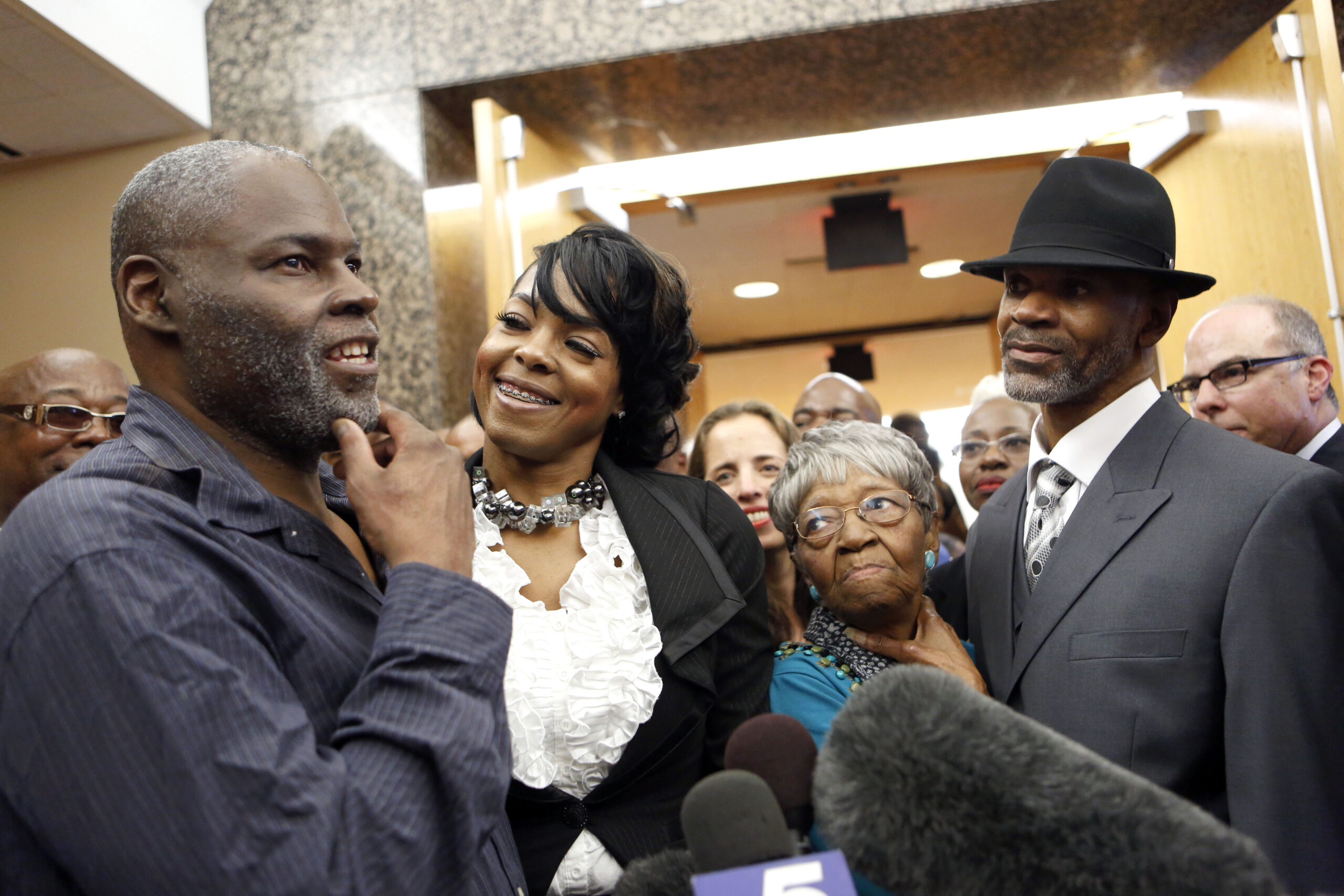 Stanley Orson Mozee, (left) represented by the InnocenceProject, with his daughter, LaTonya Mozee, (second from left) and Dennis Lee Allen, (right) represented by the Innocence Project of Texas, with his grandmother, Opealean Smith, (second from right), celebrate their freedom after Judge Mark Stoltz overturned their convictions on Tuesday, Oct. 28, 2014. (Image: Lara Solt)