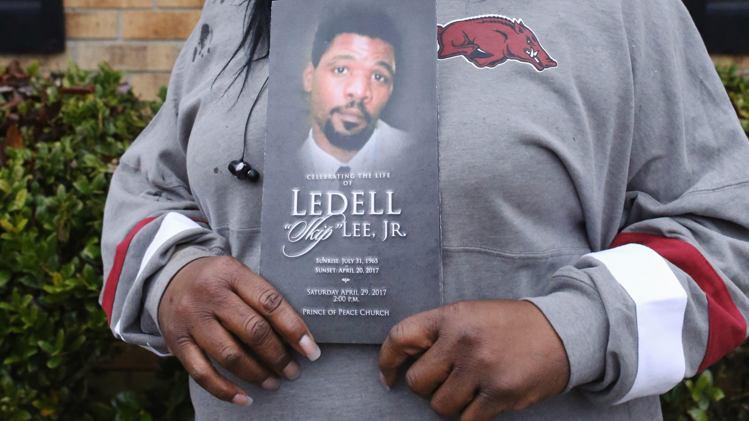 Patricia Young, Ledell Lee's sister, holds a memorial image of her brother. [Matt White/Innocence Project]
