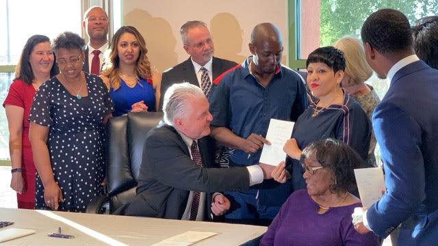 Governor SIsolak signs law with DeMarlo and Odilla Berry. 