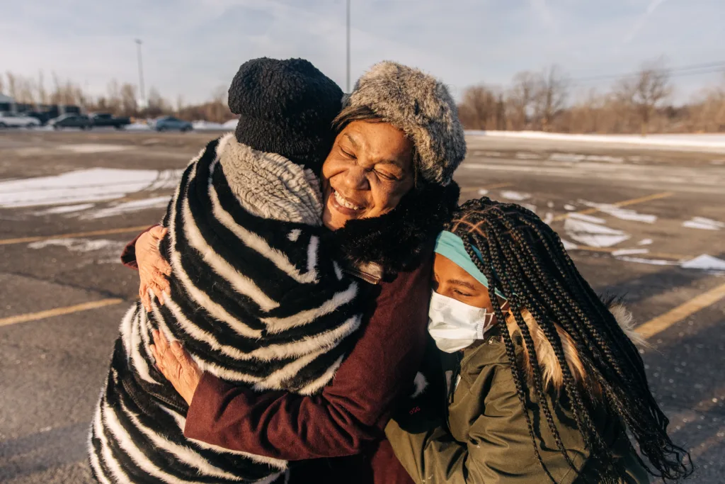 Renay Lynch hugs her daughter and granddaughter after being freed in January 2022. (Image: Jeenah Moon/Innocence Project)