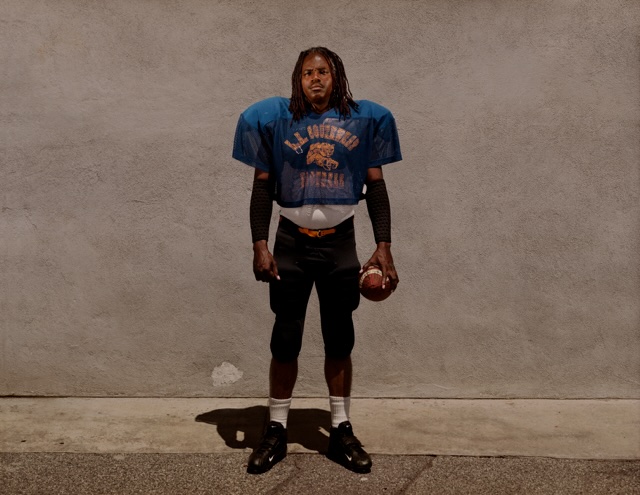 An emotionally revealing photograph of Herman Atkins in his college football jersey taken by the world renown photographer, Taryn Simon, for her book 